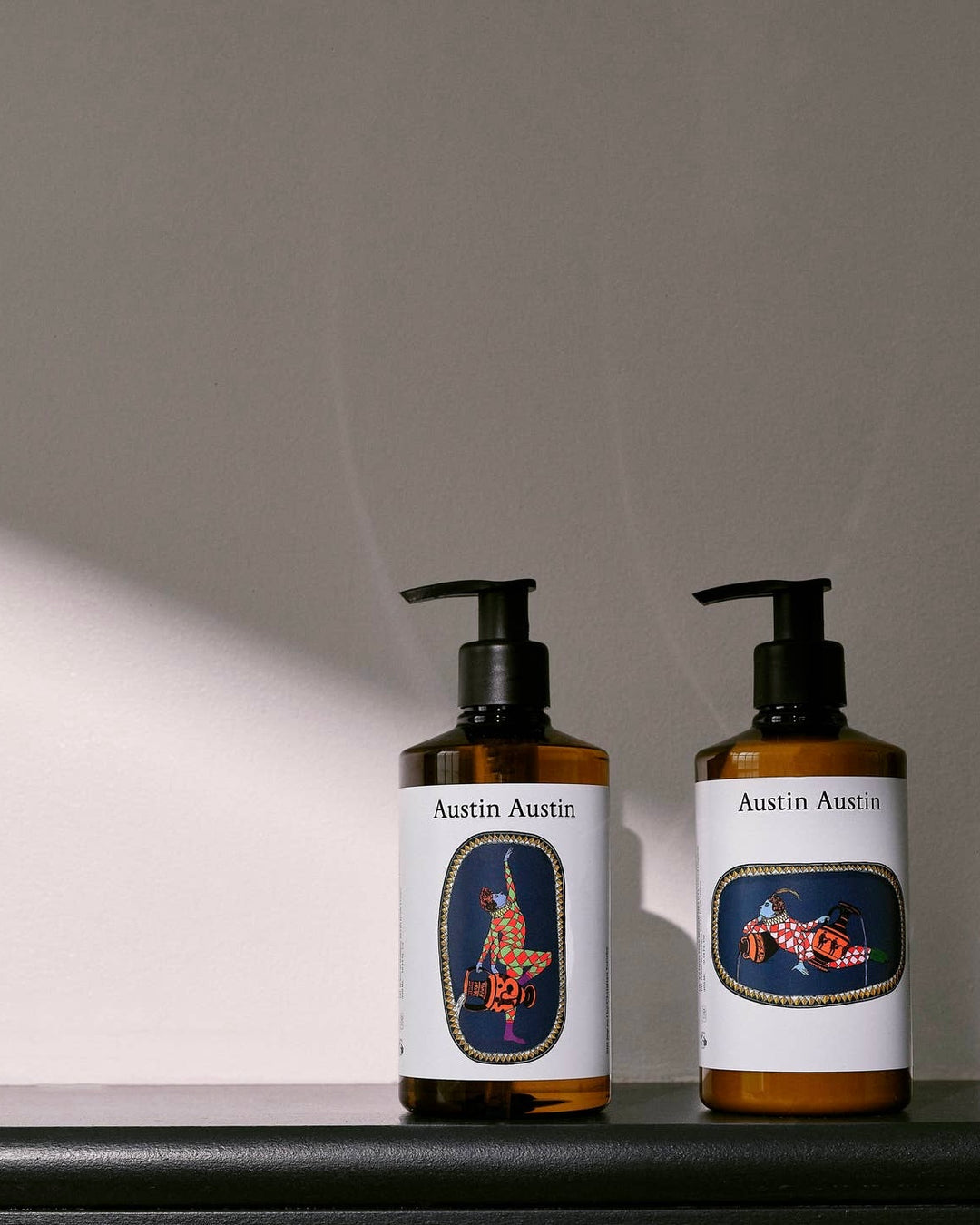 Two bottles of Austin Austin products on a gray background