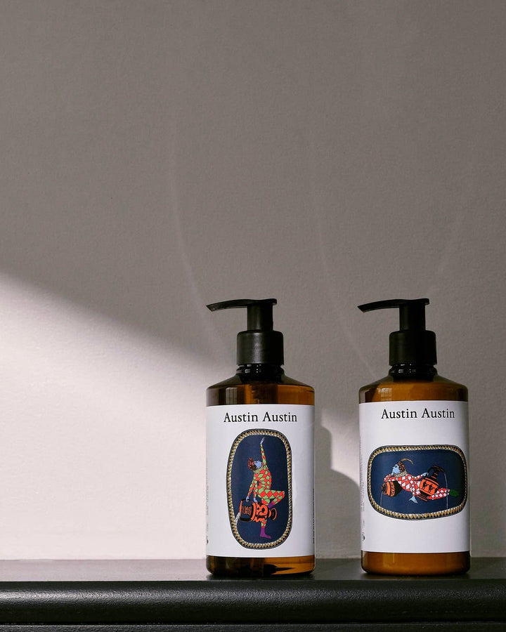 Two bottles of Austin Austin products on a gray background