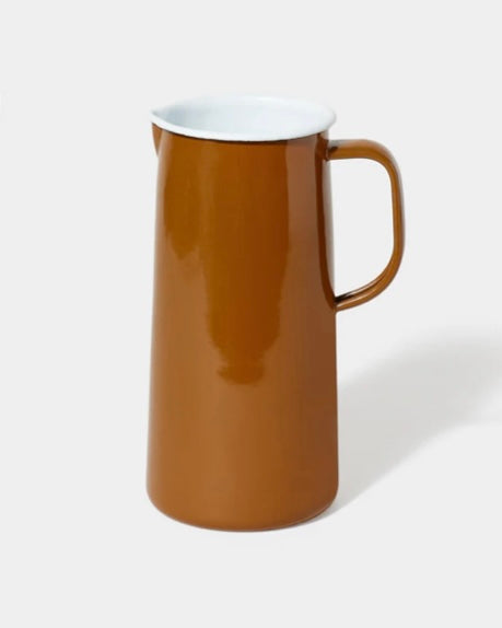 Enamel ochre pitcher with a white interior on a white background